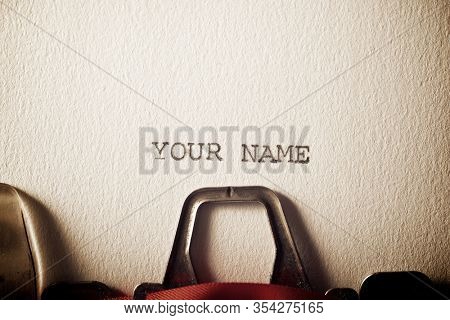 The sentence, your name, written with a typewriter.