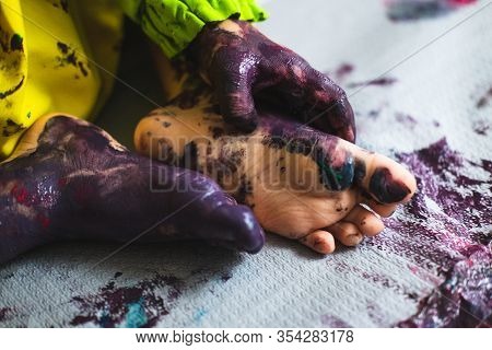 Chlid Playing With Different Color Paintings Ends With Multicolor Hands And Feet