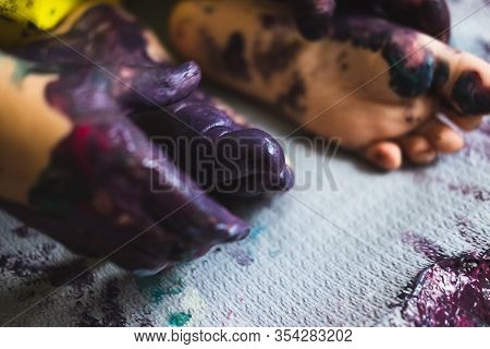 Chlid Playing With Different Color Paintings Ends With Multicolor Hands And Feet