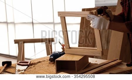 Carpenter Using Drill To Screwing Pieces Of Board At Site.