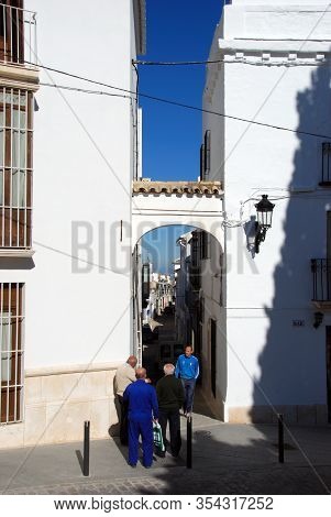 Estepa, Spain - November 13, 2008 - People Walking Through An Archway Leading Off The Plaza Del Carm