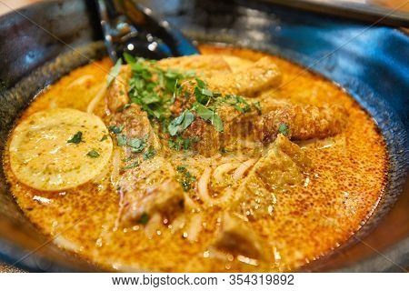 SINGAPORE - JANUARY 20, 2020: close up shot of Laksa served in the Shoppes at Marina Bay Sands. Laksa is a spicy noodle soup popular in the Peranakan cuisine of Southeast Asia