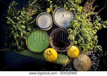 Face Mask For Acne And Blackheads On The Black Wooden Glossy Surface Consisting Of Some Cilantro Lea
