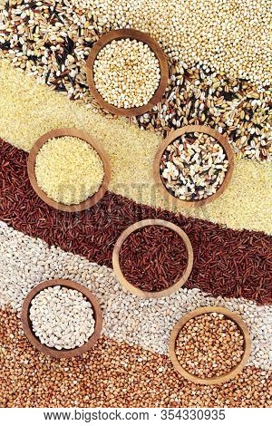 Healthy super grain food selection with puffed quinoa, multi grains, bulgur wheat, red rice, pearl barley & buckwheat. High in fibre, antioxidants, protein. minerals & vitamins. Flat lay.