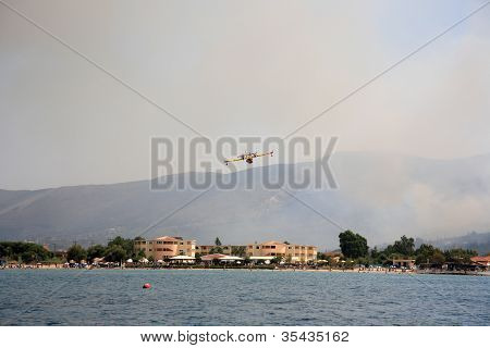 ZAKYNTHOS, Grécia - 1 de agosto: Canadair CL-415 ou Bombardier 415, aproximando-se do mar para tomar água durante
