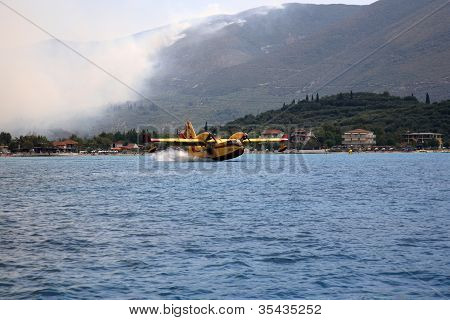 ZAKYNTHOS, Grécia - 1 de agosto: Canadair CL-415 ou Bombardier 415, aproximando-se do mar para tomar água durante