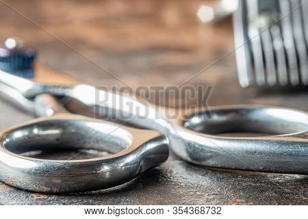 Scissors For Haircuts. Background Part Of A Clipper In Blur. Horizontal Orientation. Rusty Backgroun
