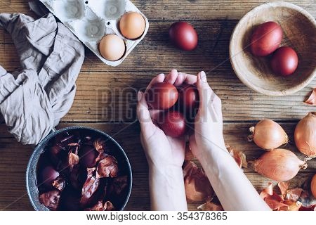 Woman Making Dyed Easter Eggs Painted With Natural Dye Onion On Wooden Background. Process Of Dyeing