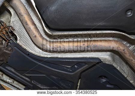 The Exhaust System In The Car Seen From Below, The Car Is On The Lift In The Car Workshop.