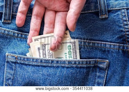 A Hand Taking Hundred Dollar Banknote From Rear Jeans Pocket