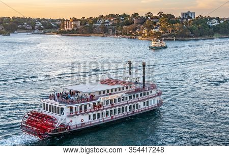 Sydney, Australia - December 11, 2009: Sunset Colors Bay Water A Shiny Blue Under Yellow Sky. Red-wh