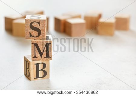 Three Wooden Cubes With Letters Smb Means Small To Medium Business , On White Table, More In Backgro