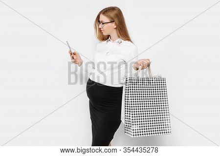 Image Of Young Pregnant Businesswoman Wearing Glasses Holding Smartphone And Bags Shopping