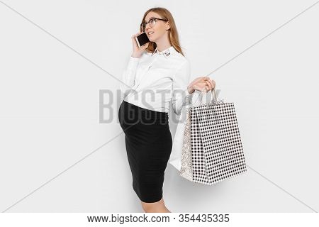 Image Of Young Pregnant Businesswoman Wearing Glasses, Talking On Phone, Holding Bags, Shopping