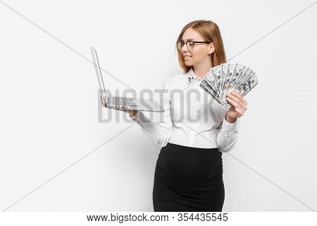 Image Of A Young Pregnant Businesswoman In Glasses Posing With A Laptop, Holding Banknotes In Her Ha