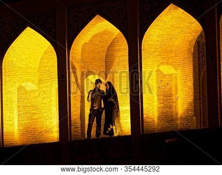 Isfahan, Iran - May 7, 2015: People Socializing On The Ancient Khaju Bridge By Night.