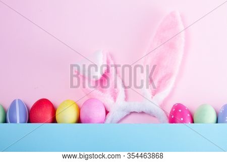 Easter Rabbit Flaffy Ears And Colored Easter Colored Eggs, Top View On Pink And Blue Plain Minimal B
