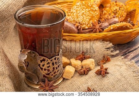 A Glass Of Tea In A Vintage Cup Holder And Cookies In A Wicker Basket On A Background Of Rough Homes