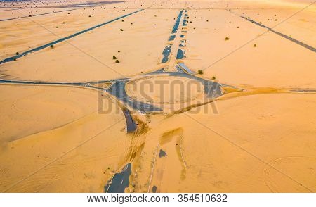 Aerial View Of Circle Roundabout, Half Desert Road Or Street With Sand Dune In Dubai City, United Ar