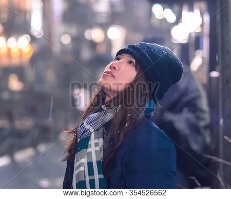 Portrait Of Female Tourist Traveling In Ginzan Onsen With Snow Falling At Night