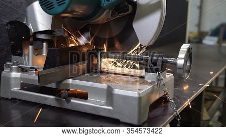Metal Grinding Machine With Sparks. Worker Sawing Steel.