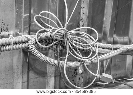 Bundle Of Tangled Wires With Switches, Communication Cables And Corrugated Hoses On The Background O