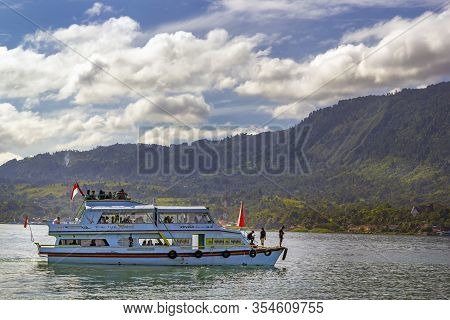 Parapat, Indonesia - January 2, 2020. Pleasure Boat Goes On The Water Against The Backdrop Of Mounta