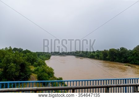 Passing Over The Bridge Over The River. The Landscape Of The River, The Surface And The Trees Of The