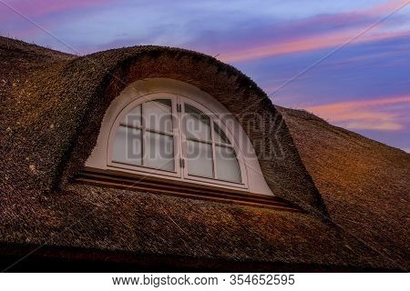 Nice Thatched Roof And Vindow In Sunset With A Beautiful Sky