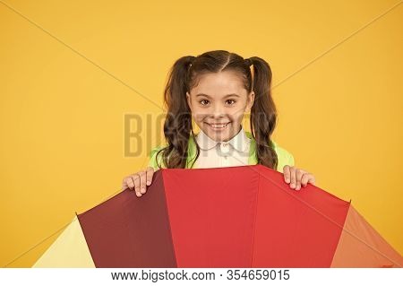 Hiding From Rain. Smiling Schoolgirl Peeking Out Of Colorful Umbrella. Autumn Rain. Going To School 
