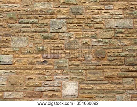 A Full Frame Image Of An Old Yellow Sandstone Wall Made Of Regular Blocks