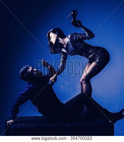 Aggressive Woman Holds In Her Hand Heels. Wife Argues With Her Husband. Be At Cross-purposes. Woman 