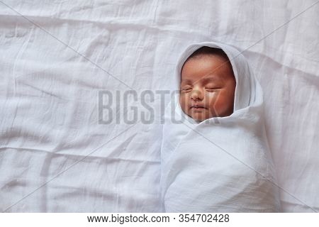 A One Month Old Baby Sleeping And Swaddled In White Cloth Lying In White Cloth Background