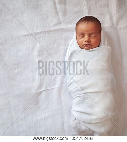A One Month Old Baby Sleeping And Swaddled In White Cloth Lying In White Cloth Background