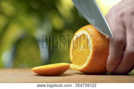 Male Hand Slicing An Orange
