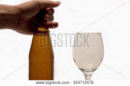 Male Hand Putting Misted Bottle Of Beer On The Table