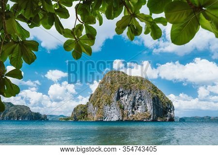 Leaves Framed Shot Of Pinagbuyutan Island. Blue Sky And White Clouds In Background. El Nido, Palawan