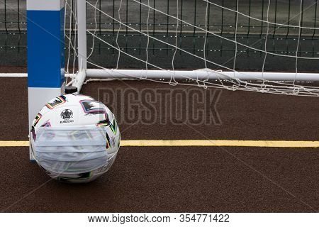 Soccer Ball With Medical Mask On Field. Euro 2020 Football Tournament. Close Up