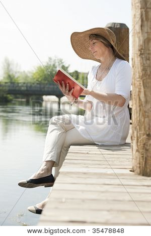 Frau sehr beim Lesen eines Buches von Fluss