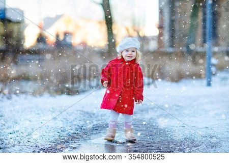 Outdoor Winter Portrait Of Little Cute Toddler Girl In Red Coat And White Fashion Hat Barret. Health