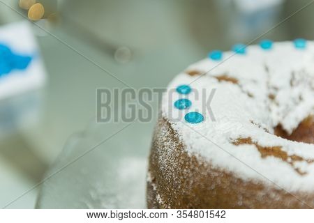 A Festive Round Cake Sprinkled With Powdered Sugar Lies.