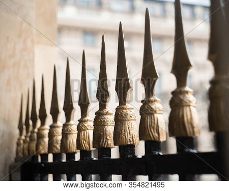 A Beautiful Ornate Iron Fence Surrounds One Of The Historical Buildings.