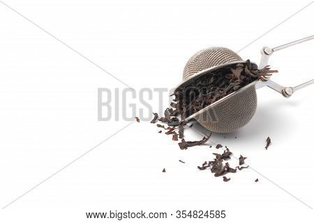 Tea Strainer With Tea Leaves On A White Background Close-up, Copy Space, Isolate
