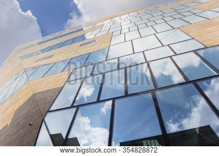 Groningen, Netherlands - March 07, 2020: Blue Sky And Whit Clouds Reflected In The Windows Of The Fo