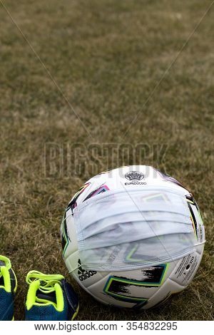 Soccer Ball With Medical Mask On Field. Euro 2020 Football Tournament. Close Up
