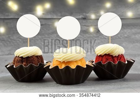 This Cupcake Topper Mock Up Features Three Delicious Gourmet Cupcakes On A Weathered Gray Wood Backg