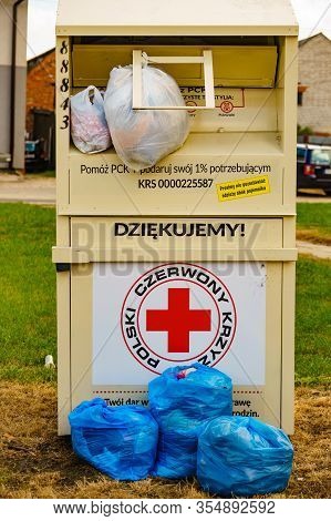Skarlin, Poland - July 18, 2019: Container Of The Polish Red Cross For Used Donated Clothing, Shoes 
