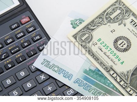 One American Dollar And 1000 Russian Rubles With A Black Calculator. Devaluation And Depreciation Of