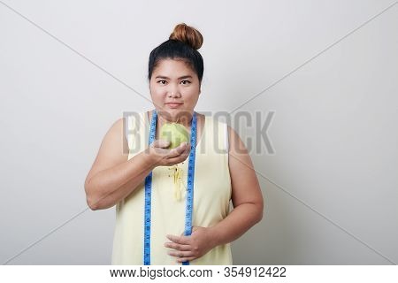 Overweight Woman Eating Food On Gray Background