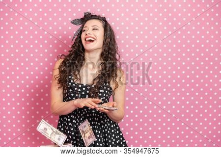 Joyful Young Female Is Throwing Dollar Banknotes Out From Her Palm One By One And Laughing Desparate